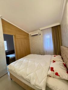 a bedroom with a white bed with red flowers on it at Budva house Maja in Budva