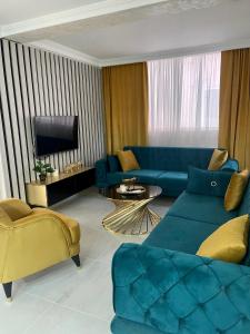 a living room with a blue couch and a tv at Budva house Maja in Budva
