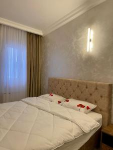 sypialnia z białym łóżkiem z czerwonymi kwiatami w obiekcie Budva house Maja w Budvie