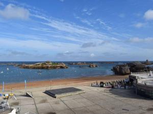 a view of a beach with an island in the water at Appartement Trégastel, 3 pièces, 4 personnes - FR-1-368-29 in Trégastel