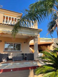 una casa con un patio con sillas frente a ella en Willa con piscina, en El Vendrell