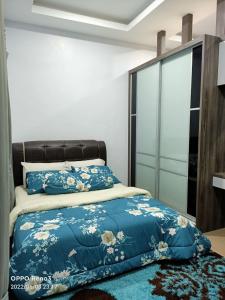 a bedroom with a bed with a blue comforter at Tambun Hillview Cottage in Tambun