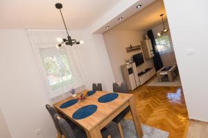 a dining room table and chairs in a living room at Apartman Studio Blue in Subotica