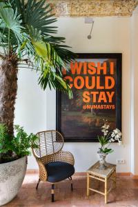 a room with a chair and a sign that reads wish i could stayromyromy at numa I Belfort Rooms & Apartments in Berlin