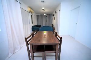 a dining room table with chairs and a couch at Jeff and Ricky Homestay Matang Metrocity in Kuching