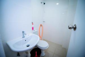 a white bathroom with a sink and a toilet at Jeff and Ricky Homestay Matang Metrocity in Kuching