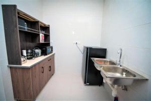 a small bathroom with a sink and a counter at Jeff and Ricky Homestay Matang Metrocity in Kuching