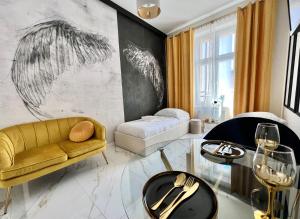 een woonkamer met een gele bank en een tafel bij Art Apartments Warszawska 21 Katowice in Katowice