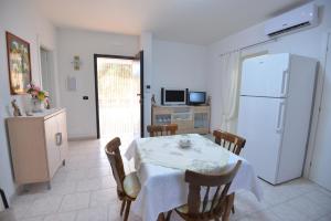 a kitchen with a table and a white refrigerator at Villa del Sole in Ostuni