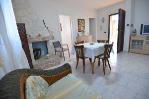 a living room with a table and chairs and a fireplace at Villa del Sole in Ostuni