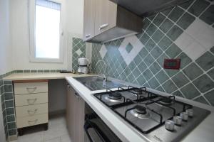 een keuken met een fornuis en een spoelbak bij Villa del Sole in Ostuni