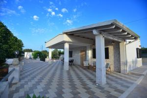 een paviljoen met een dak op een patio bij Villa del Sole in Ostuni