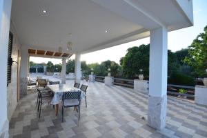 een grote patio met een tafel en stoelen erop bij Villa del Sole in Ostuni