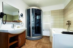 a bathroom with a shower and a sink and a tub at Casa Chilia Resort&Spa in Chilia Veche