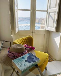 una mesa con un libro y una silla con una ventana en Spacious maisonette with spectacular views IBRI1-1, en La Valeta