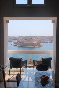 ein großes Fenster mit einem großen Schiff im Wasser in der Unterkunft Spacious maisonette with spectacular views IBRI1-1 in Valletta