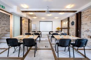 a classroom with tables and chairs in a room with brick walls at Plaza Residence Self Check-in in Krakow +37 photos
