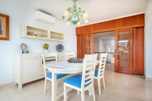 a kitchen and dining room with a white table and chairs at Villa Enderrossall in Porto Cristo