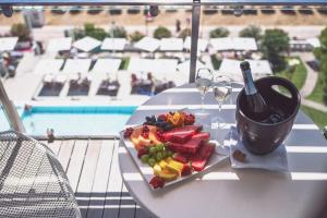 uma mesa branca com um prato de frutas e taças de vinho em Hotel Cesare Augustus em Lido di Jesolo