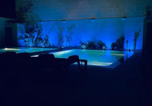 a dark room with a swimming pool at night at Fiftyfour West Boutique Living in Għarb