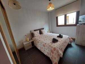 a bedroom with a bed with two bags on it at Aldea Bricia 20 Jardin in Posada de Llanes