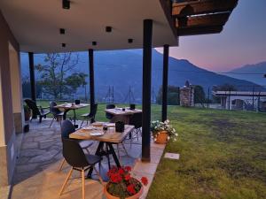 un patio con mesas y sillas y vistas al océano en Arlette Chambres d'Hôtes, en Aosta