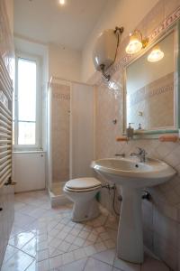 W łazience znajduje się umywalka, toaleta i lustro. w obiekcie ROMAMOREMIO w Rzymie