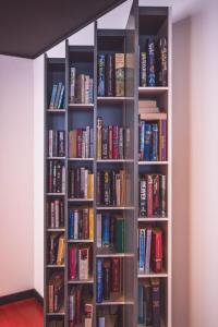 a book shelf filled with lots of books at Hotel Cesare Augustus in Lido di Jesolo