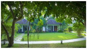 una casa con césped delante en Seclude Kerala, Marari Sands, en Mararikulam