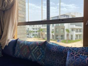 a couch sitting in front of a window with a view at Hivernage, Superbe appartement dans une résidence in Agadir