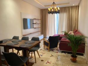 uma sala de estar com uma mesa e um sofá em Hivernage, Superbe appartement dans une résidence em Agadir