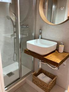 a bathroom with a sink and a shower with a mirror at Hotel Boutique Room Tarifa in Tarifa