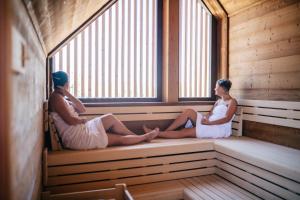 a man and a woman sitting in a sauna at Resort Lednice - Eisgrub in Lednice