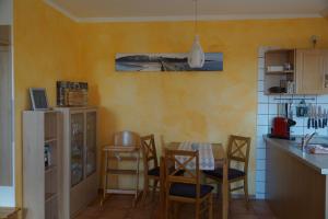 eine Küche mit einem Tisch und Stühlen im Zimmer in der Unterkunft Ferienwohnung Koserow in Ostseebad Koserow