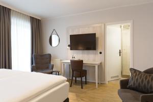 een hotelkamer met een bed en een bureau bij Koopmanns Hotel und Lädchen in Göhren