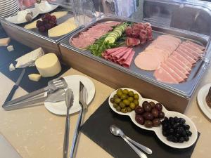 a table with a tray of food with meat and vegetables at Fiftyfour West Boutique Living in Għarb