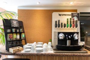 a counter with a coffee machine on a table at Eco Hotel Toledo in Toledo