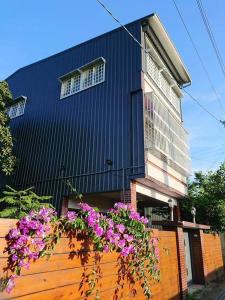 新社區的住宿－新社小宿食光包棟民宿，一座黑色的建筑,在木栅栏上种着紫色的花