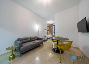 a living room with a couch and a table at MALAGA CENTRAL SUITES - New Release in Málaga
