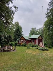 a red house with a picnic table and a tent at Idyllinen mökki Laitilassa in Laitila