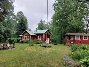 una casa roja con un patio delante en Idyllinen mökki Laitilassa, en Laitila