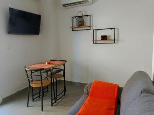 ein Wohnzimmer mit einem Tisch und einem Sofa in der Unterkunft Rentaly Holidays Apartamento Artes de Arcos Almería in Almería