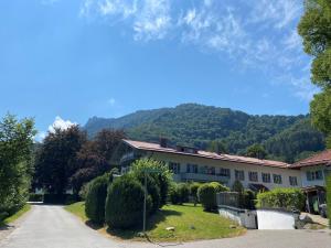 una casa en un camino con una montaña en el fondo en Ferienwohnung Johannsen Haus Elisabeth en Aschau im Chiemgau