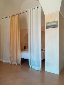 una camera con letto e tende di Kuddia Attalora a Pantelleria