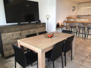 弗朗科爾尚的住宿－Baronheid，用餐室配有木桌、椅子和电视