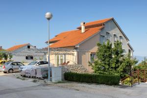 a house with a car parked in front of it at Double Room Njivice 5458a in Njivice