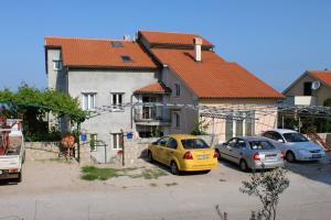 dwa samochody zaparkowane na parkingu przed domem w obiekcie Studio Njivice 5458a w mieście Nijvice