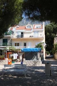 Apartments by the sea Drvenik Donja vala, Makarska - 6658 في درفينيك: مبنى ابيض كبير عليه قماش ازرق