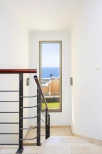 Una escalera en una casa con ventana en Chalet con vistas al mar en Santa Cruz de Tenerife en Santa Cruz de Tenerife