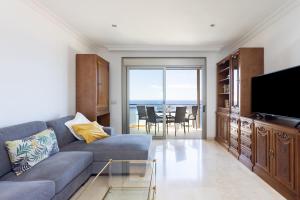 een woonkamer met een bank, een televisie en een tafel bij Chalet con vistas al mar en Santa Cruz de Tenerife in Santa Cruz de Tenerife